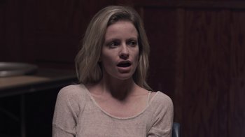 Movie still from “The Amityville Moon” (2021), directed by Thomas J. Churchill – A woman with her mouth wide open looking at the camera; Close Up shot, Over the shoulder angle
