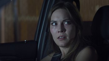 Movie still from “The Amityville Moon” (2021), directed by Thomas J. Churchill – A person sitting in a car; Close Up shot, Over the shoulder angle
