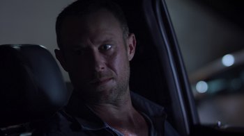 Movie still from “The Amityville Moon” (2021), directed by Thomas J. Churchill – A person in a car looking at the camera; Close Up shot, Over the shoulder angle