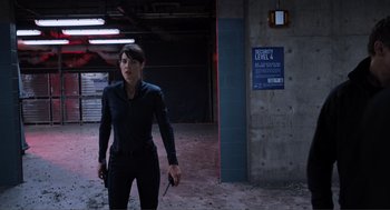 Movie still from “The Avengers” (2012), directed by Joss Whedon – A woman in a black outfit is holding a knife; Medium shot, Low angle