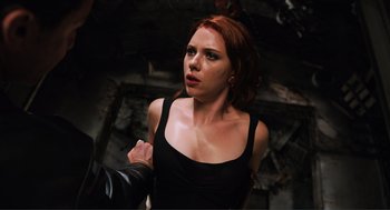 Movie still from “The Avengers” (2012), directed by Joss Whedon – A woman in a black top is holding a gun; Close Up shot, Overhead angle