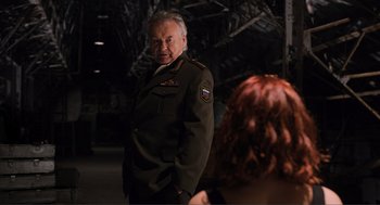 Movie still from “The Avengers” (2012), directed by Joss Whedon – An older man in a military uniform standing next to a woman; Medium shot, Over the shoulder angle