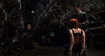 Movie still from “The Avengers” (2012), directed by Joss Whedon – A man and a woman are standing in a dark room; Wide shot, Over the shoulder angle