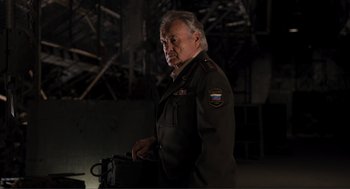 Movie still from “The Avengers” (2012), directed by Joss Whedon – An older man in a military uniform is holding something in his hand; Medium shot, Low angle