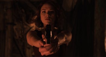 Movie still from “The Avengers” (2012), directed by Joss Whedon – A woman holding a gun in a dark room; Medium shot, Low angle