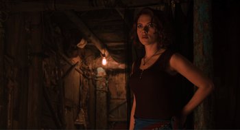 Movie still from “The Avengers” (2012), directed by Joss Whedon – A woman standing in a dark room with a candle in the background; Medium shot, Low angle