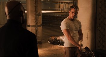 Movie still from “The Avengers” (2012), directed by Joss Whedon – A man standing next to a dead body in a room; Medium shot, Over the shoulder angle