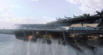 Movie still from “The Avengers” (2012), directed by Joss Whedon – An airplane is flying over a bridge with water coming out of it; Extreme Wide shot, Low angle
