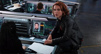 Movie still from “The Avengers” (2012), directed by Joss Whedon – A woman sitting in front of computer monitors; Medium shot, Over the shoulder angle