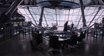 Movie still from “The Avengers” (2012), directed by Joss Whedon – People are sitting around a table in an airport; Wide shot, High angle