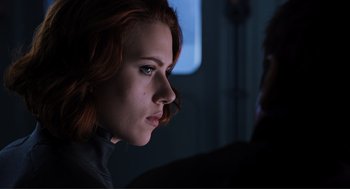 Movie still from “The Avengers” (2012), directed by Joss Whedon – A person with red hair looking at something; Close Up shot, Over the shoulder angle