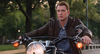 Movie still from “The Avengers” (2012), directed by Joss Whedon – A man sitting on the back of a parked motorcycle; Medium shot, Low angle