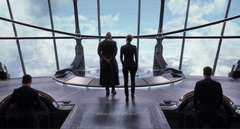 Movie still from “The Avengers” (2012), directed by Joss Whedon – Two people are standing in front of a large window; Wide shot, Low angle
