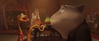 Movie still from “The Bad Guys” (2022), directed by Pierre Perifel – A group of people sitting at a table with an elephant; Wide shot, High angle