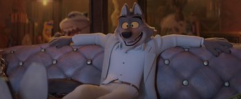 Movie still from “The Bad Guys” (2022), directed by Pierre Perifel – A wolf character sitting on a couch in a room; Medium shot, Over the shoulder angle