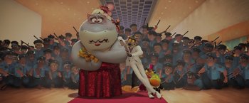 Movie still from “The Bad Guys” (2022), directed by Pierre Perifel – A woman standing in front of a large statue of a hippo; Wide shot, Low angle