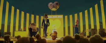 Movie still from “The Bad Guys” (2022), directed by Pierre Perifel – A group of people on a stage in a room; Wide shot, Low angle