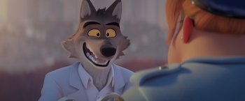Movie still from “The Bad Guys” (2022), directed by Pierre Perifel – An animated wolf wearing a lab coat and smiling at a person; Close Up shot, Over the shoulder angle