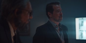 Movie still from “The Big 4” (2022), directed by Timo Tjahjanto – A man in a suit and tie standing next to another man in a suit and tie; Close Up shot, Over the shoulder angle