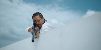 Movie still from “The Big 4” (2022), directed by Timo Tjahjanto – A woman is aiming a rifle at the sky; Close Up shot, Low angle