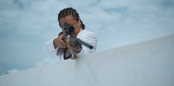 Movie still from “The Big 4” (2022), directed by Timo Tjahjanto – A woman is holding a rifle and aiming it; Medium shot, Low angle