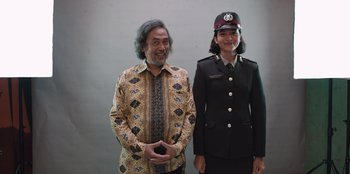 Movie still from “The Big 4” (2022), directed by Timo Tjahjanto – A man standing next to a woman wearing a uniform; Medium shot, Low angle