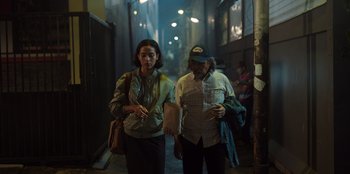 Movie still from “The Big 4” (2022), directed by Timo Tjahjanto – A man and a woman walking down a street; Medium shot, High angle