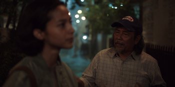 Movie still from “The Big 4” (2022), directed by Timo Tjahjanto – An older man and a young woman standing next to each other on the street; Close Up shot, Over the shoulder angle