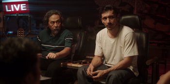 Movie still from “The Big 4” (2022), directed by Timo Tjahjanto – Two men sitting in a room next to each other; Medium shot, Low angle