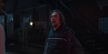 Movie still from “The Big 4” (2022), directed by Timo Tjahjanto – An older man standing in a dark room; Medium shot, Over the shoulder angle