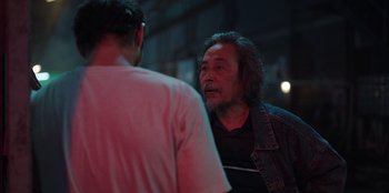 Movie still from “The Big 4” (2022), directed by Timo Tjahjanto – A man talking to another man in a dark room; Close Up shot, Over the shoulder angle
