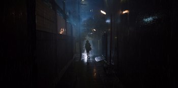 Movie still from “The Big 4” (2022), directed by Timo Tjahjanto – A person walking down a street in the rain; Extreme Wide shot, Low angle