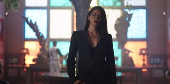 Movie still from “The Big 4” (2022), directed by Timo Tjahjanto – A woman in a black suit standing in front of a stained glass window; Medium shot, Low angle