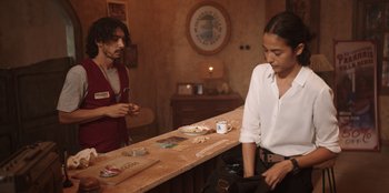 Movie still from “The Big 4” (2022), directed by Timo Tjahjanto – A man and a woman standing at a counter; Medium shot, Over the shoulder angle