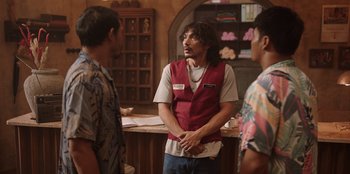 Movie still from “The Big 4” (2022), directed by Timo Tjahjanto – A group of men standing around a counter; Medium shot, Over the shoulder angle