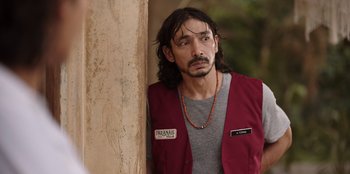 Movie still from “The Big 4” (2022), directed by Timo Tjahjanto – A man with long black hair wearing a red vest; Close Up shot, Over the shoulder angle