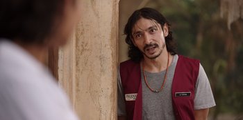 Movie still from “The Big 4” (2022), directed by Timo Tjahjanto – A man with long black hair wearing a red vest; Close Up shot, Over the shoulder angle