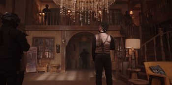 Movie still from “The Big 4” (2022), directed by Timo Tjahjanto – A man standing in front of a chandelier in a room; Wide shot, Low angle