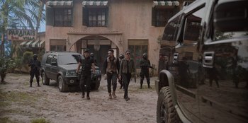 Movie still from “The Big 4” (2022), directed by Timo Tjahjanto – A group of people walking down a street near a building; Wide shot, Low angle