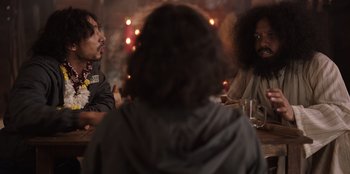 Movie still from “The Big 4” (2022), directed by Timo Tjahjanto – A group of people sitting around a table; Medium shot, Over the shoulder angle
