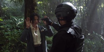 Movie still from “The Big 4” (2022), directed by Timo Tjahjanto – A man in a black helmet and a woman in a white jacket; Medium shot, Over the shoulder angle