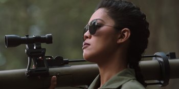 Movie still from “The Big 4” (2022), directed by Timo Tjahjanto – A woman with sunglasses is holding a rifle; Close Up shot, Low angle