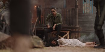 Movie still from “The Big 4” (2022), directed by Timo Tjahjanto – A woman standing over a man laying on the ground; Wide shot, Low angle