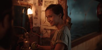 Movie still from “The Big 4” (2022), directed by Timo Tjahjanto – A woman smiles as she uses an electric iron; Close Up shot, Over the shoulder angle