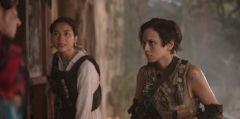 Movie still from “The Big 4” (2022), directed by Timo Tjahjanto – Two young women are standing next to each other holding guns; Close Up shot, Over the shoulder angle