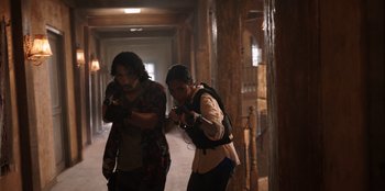 Movie still from “The Big 4” (2022), directed by Timo Tjahjanto – A couple of people that are walking in a hallway; Medium shot, Low angle