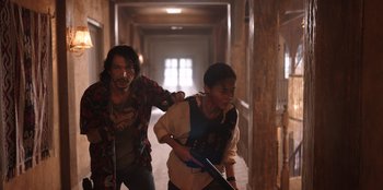 Movie still from “The Big 4” (2022), directed by Timo Tjahjanto – A man and a woman are walking in a hallway; Medium shot, Over the shoulder angle