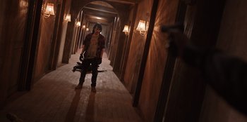 Movie still from “The Big 4” (2022), directed by Timo Tjahjanto – A man in a hallway holding a pair of umbrellas; Wide shot, Low angle