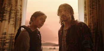 Movie still from “The Big 4” (2022), directed by Timo Tjahjanto – Two men standing next to each other near a body of water; Medium shot, Low angle