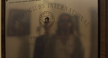 Movie still from “The Big Lebowski” (1998), directed by Ethan Coen – A picture of a mirror with a picture of a person in the reflection; Extreme Close Up shot, Low angle